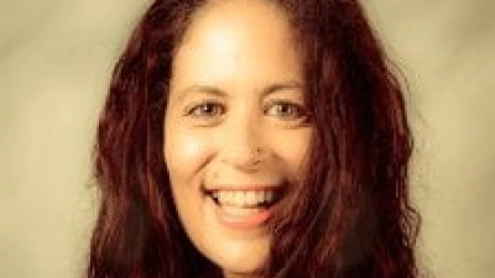 A woman with brown hair smiling.