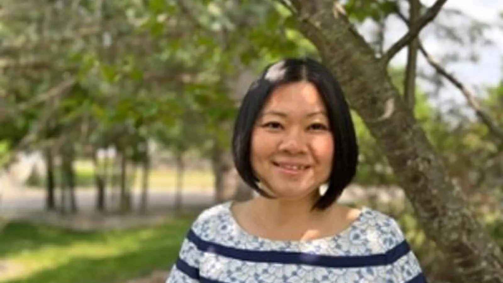 A woman with black hair smiling.