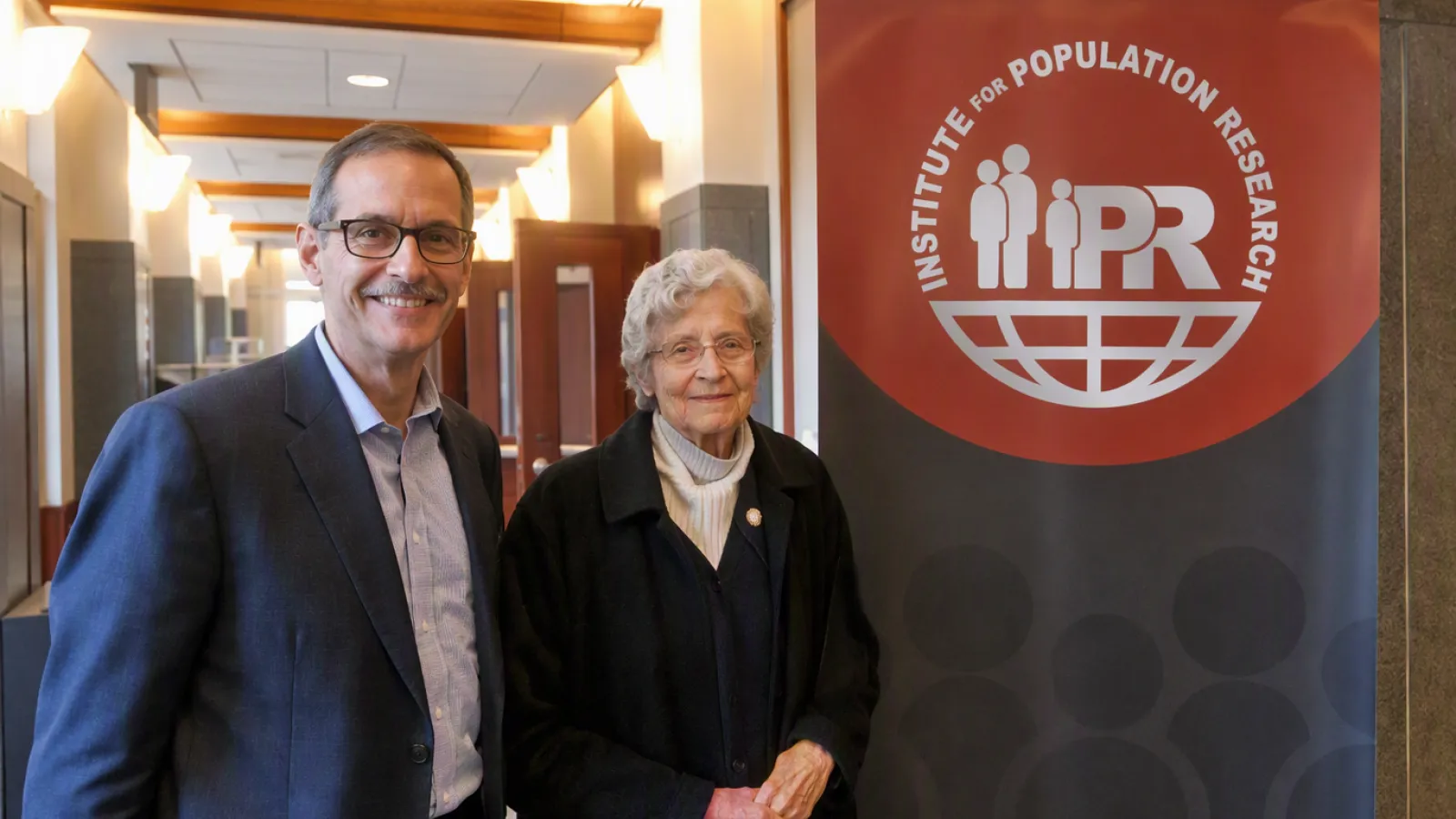 Dr. Joan Huber and Dr. Joseph Potter standing by an IPR sign